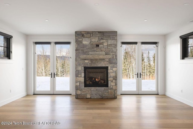 unfurnished living room featuring french doors, plenty of natural light, and wood finished floors