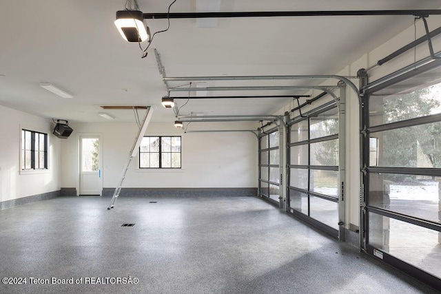 garage featuring a garage door opener and baseboards