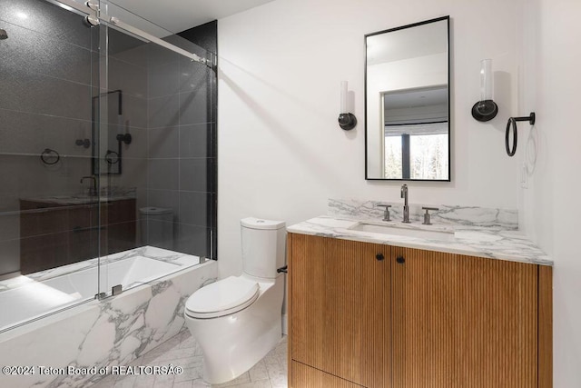 bathroom with enclosed tub / shower combo, vanity, and toilet