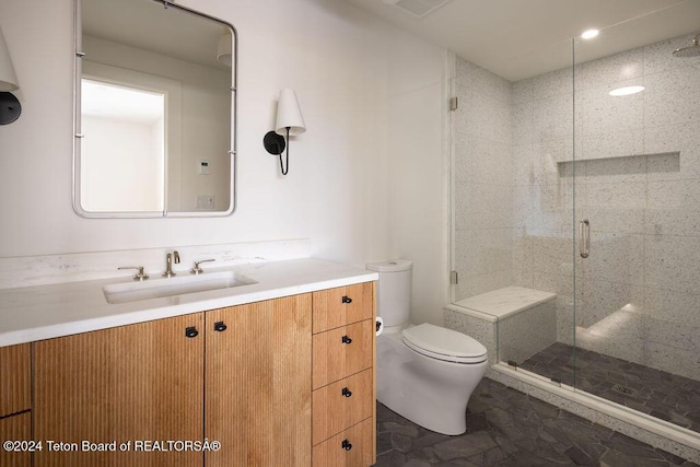 bathroom with a stall shower, vanity, and toilet