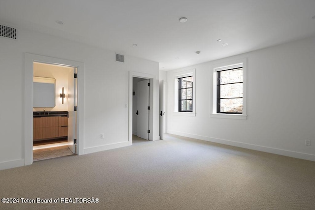 unfurnished bedroom featuring light carpet, visible vents, and baseboards