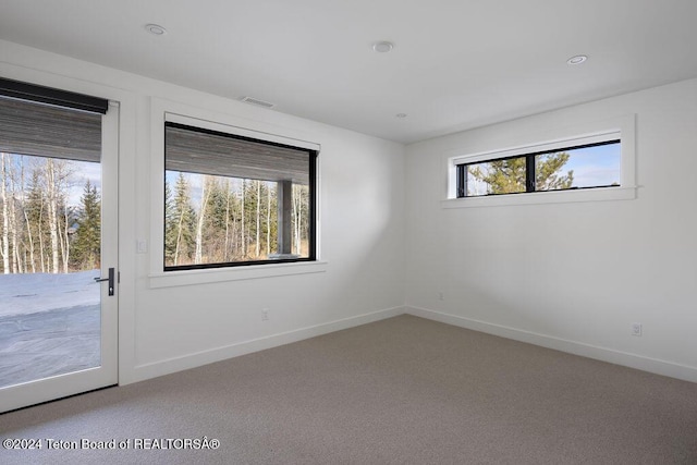 unfurnished room with carpet floors, recessed lighting, visible vents, and baseboards