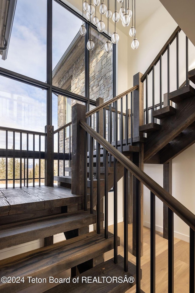 stairway with a high ceiling and wood finished floors