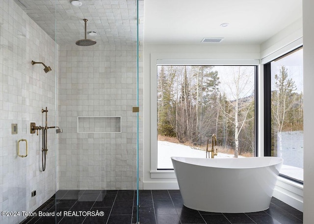 bathroom with a freestanding bath, a stall shower, tile patterned flooring, and visible vents