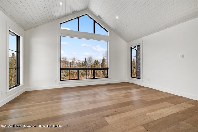 spare room featuring lofted ceiling, wooden ceiling, baseboards, and wood finished floors