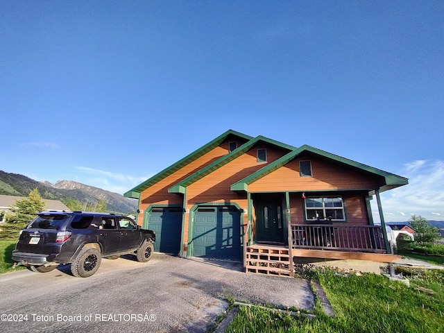 view of front of house featuring a mountain view, a porch, and a garage