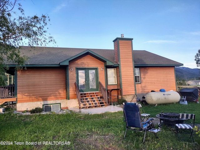 rear view of house featuring a yard and a fire pit