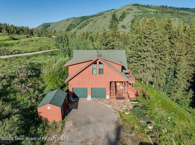 birds eye view of property featuring a view of trees and a mountain view