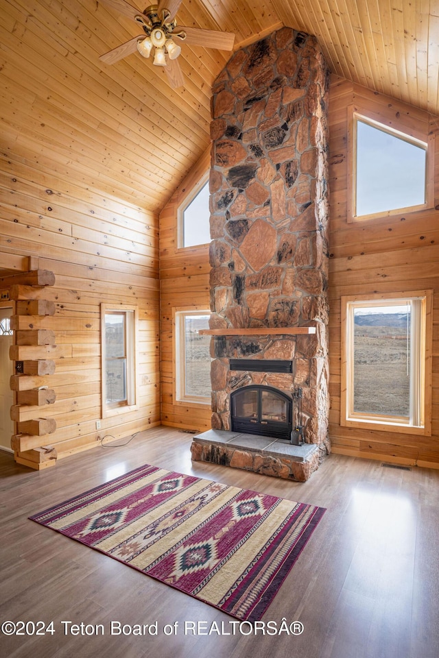6 Black Bear Rd, Pinedale, WY 82941 - unfurnished living room with wooden ceiling, high vaulted ceiling, wood finished floors, a stone fireplace, and wooden walls