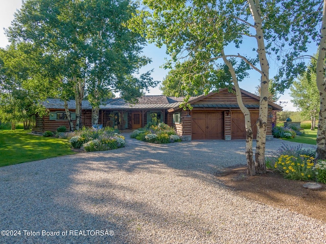 log cabin featuring a front yard and a garage