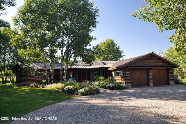 log-style house featuring a garage and a front lawn