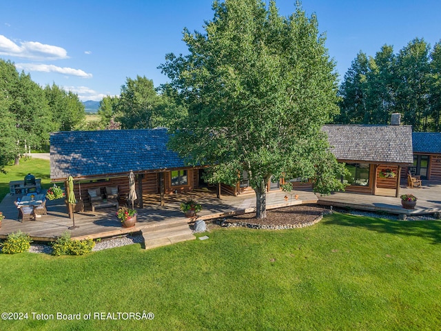 view of front of house with a deck and a front lawn