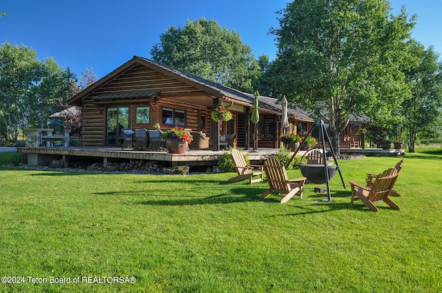 back of property featuring a deck and a lawn