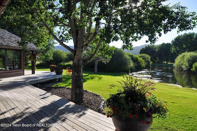 deck featuring a water view and a yard