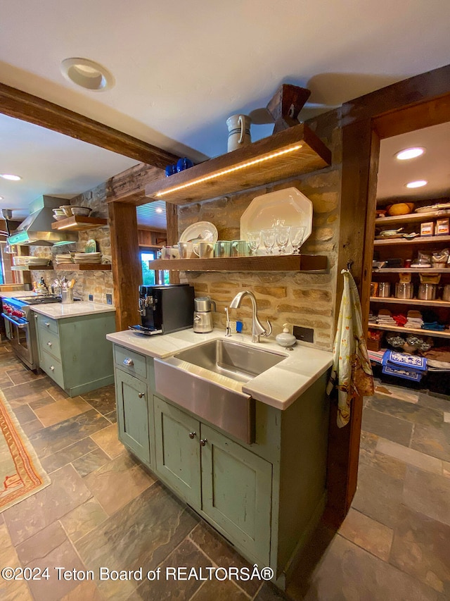 kitchen featuring double oven range, dark tile floors, green cabinets, and sink