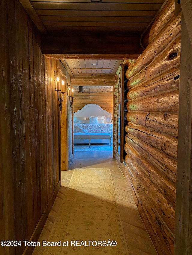 hall with wooden ceiling, log walls, light wood-type flooring, and beamed ceiling