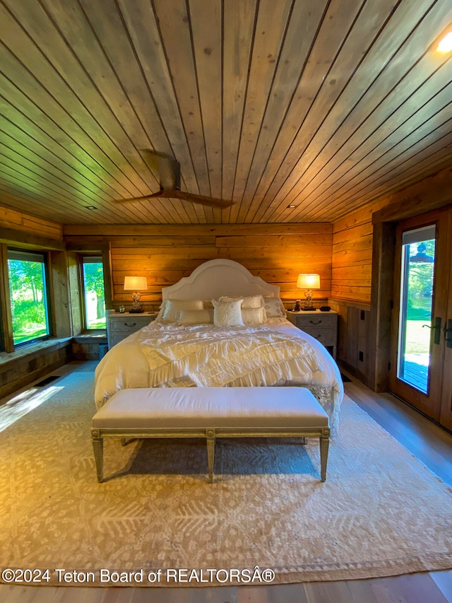 bedroom featuring wood ceiling, wood walls, access to outside, and multiple windows