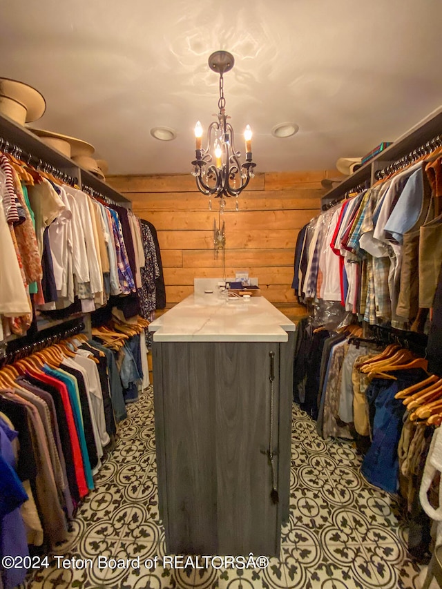 spacious closet featuring a notable chandelier and light tile flooring