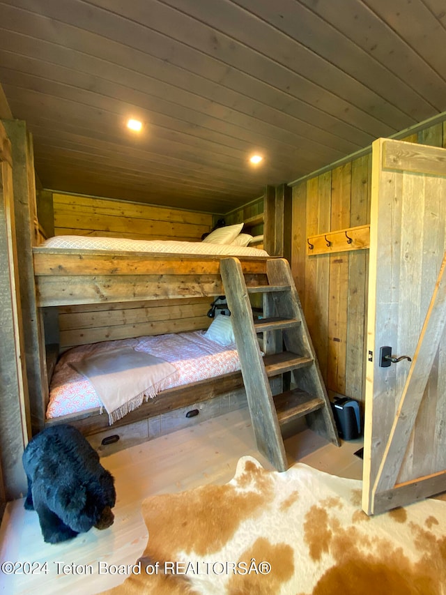 bedroom featuring wood-type flooring, wooden walls, and wood ceiling