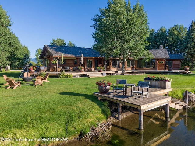 back of house with a wooden deck and a lawn