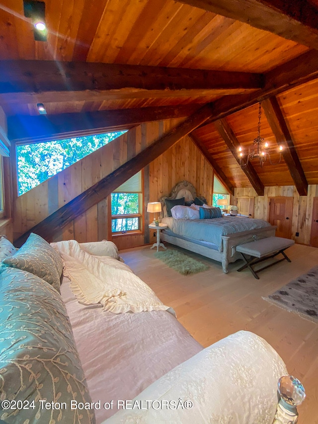 bedroom with lofted ceiling with beams, wooden ceiling, wood walls, and light wood-type flooring