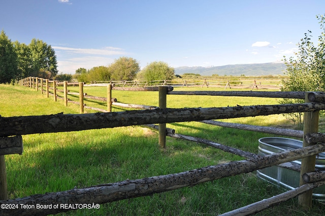 view of gate with a yard and a rural view