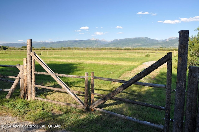 view of gate featuring a mountain view, a rural view, and a yard