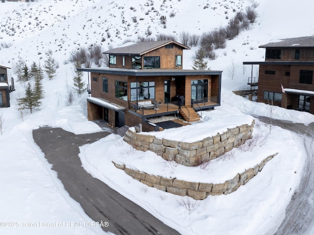 snow covered property with a porch