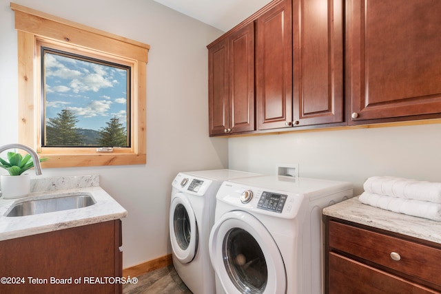 washroom with washer and clothes dryer, cabinets, sink, and wood-type flooring