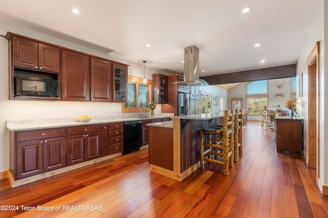 kitchen with black appliances, island exhaust hood, a center island, and dark hardwood / wood-style flooring