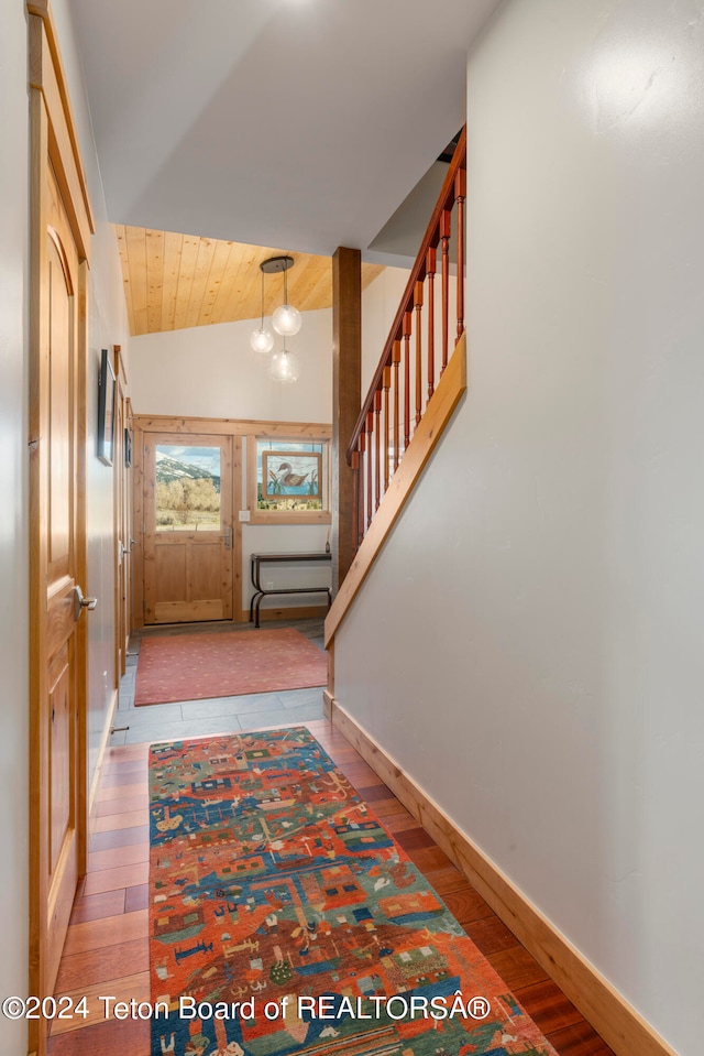 entrance foyer featuring light hardwood / wood-style flooring, wood ceiling, vaulted ceiling, and a chandelier