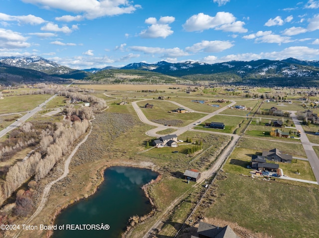 drone / aerial view featuring a rural view and a water and mountain view