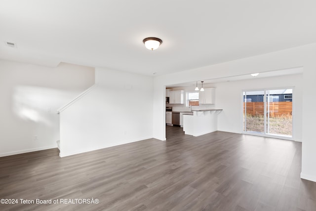 unfurnished living room with dark wood-type flooring and sink