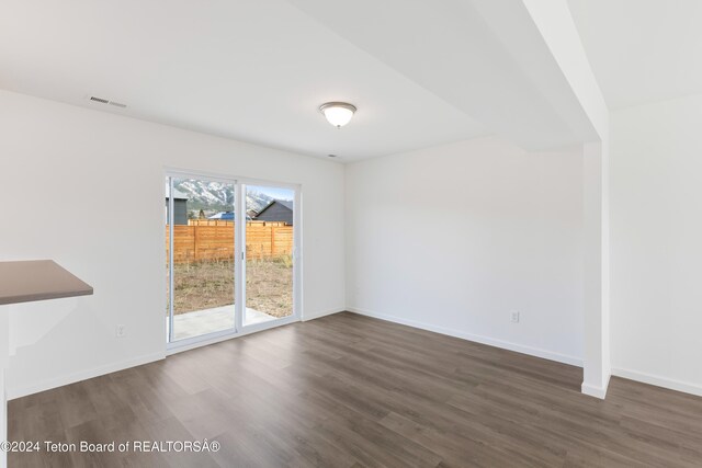 unfurnished room featuring dark hardwood / wood-style flooring