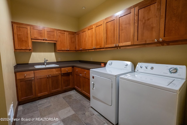 laundry area featuring tile patterned floors, sink, cabinets, and washer and clothes dryer