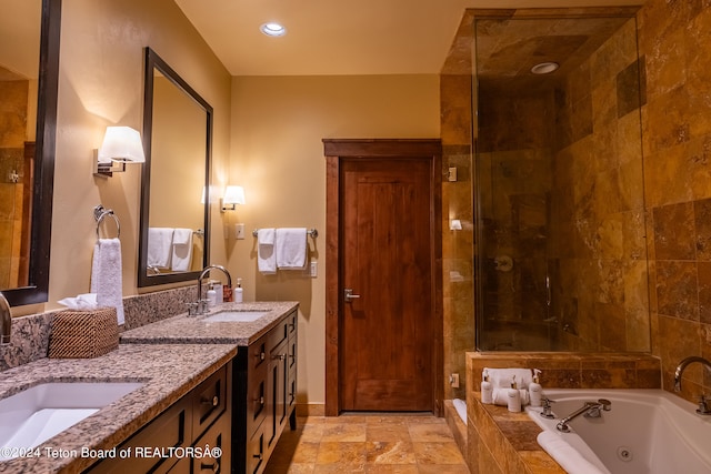 bathroom with a relaxing tiled tub, dual vanity, and tile patterned floors