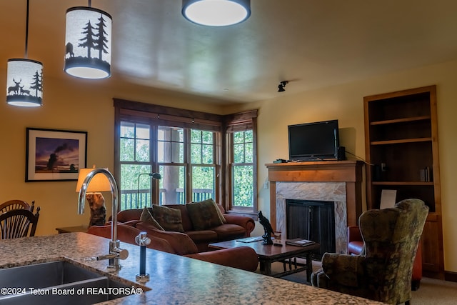 living room featuring a fireplace, carpet flooring, built in shelves, and sink