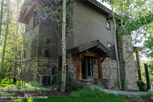 view of side of home with central AC unit