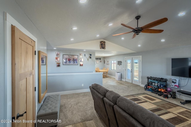 living room featuring french doors, lofted ceiling, a textured ceiling, ceiling fan, and light colored carpet