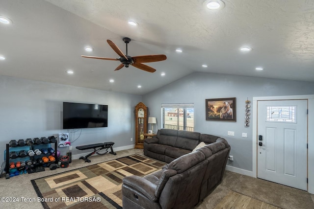 living room featuring ceiling fan, lofted ceiling, and a textured ceiling