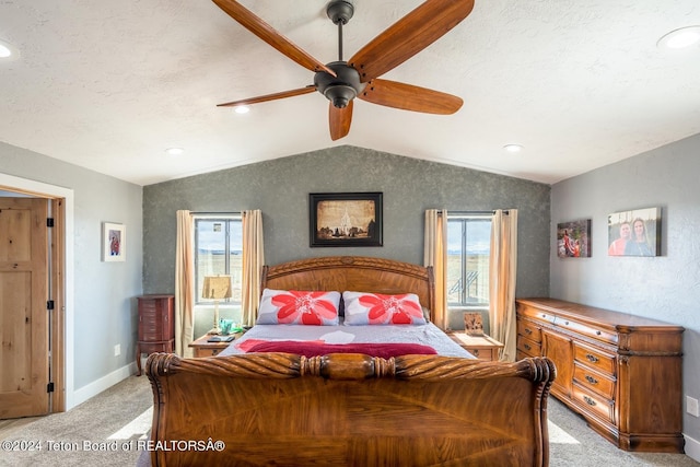 carpeted bedroom featuring lofted ceiling, ceiling fan, and a textured ceiling