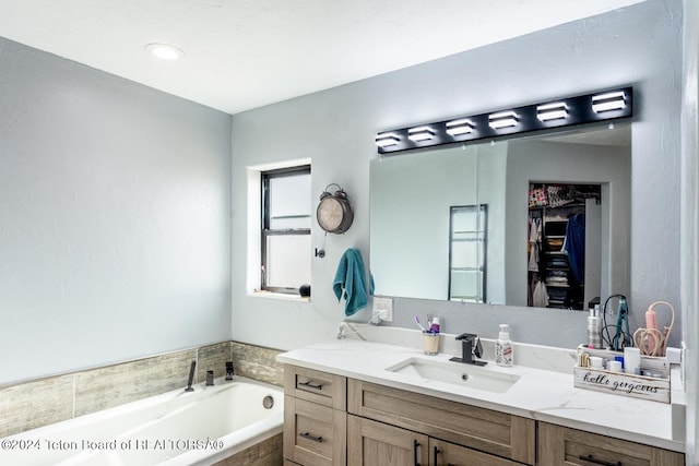 bathroom with vanity and tiled bath