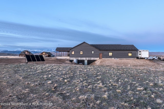 view of property exterior featuring a mountain view and solar panels