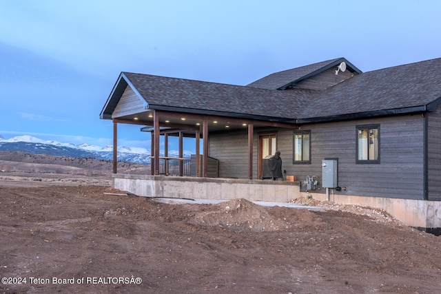 back of house with a mountain view and covered porch