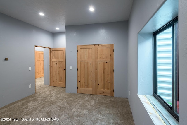 unfurnished bedroom featuring light carpet