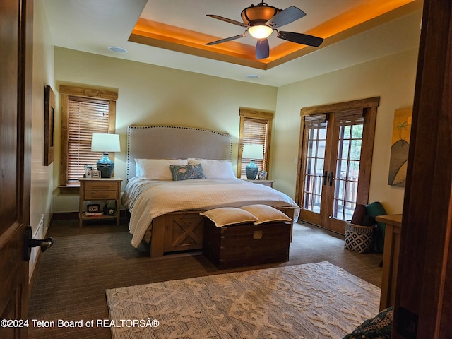 bedroom featuring french doors, access to exterior, dark colored carpet, ceiling fan, and a tray ceiling