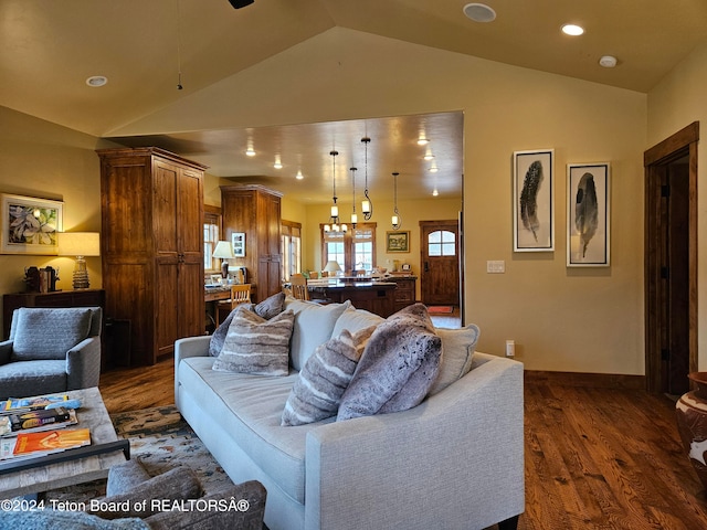 living room featuring a chandelier, dark hardwood / wood-style flooring, and vaulted ceiling