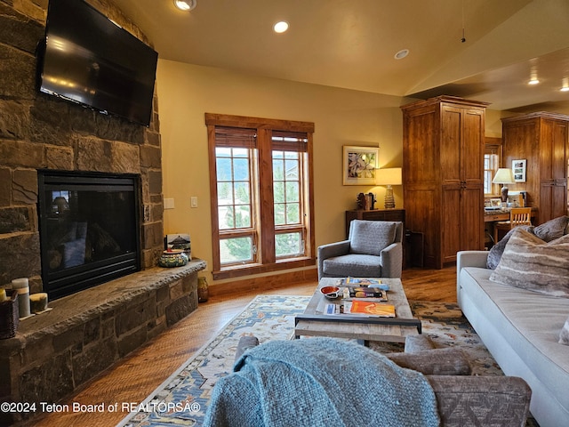 living room with a fireplace, wood-type flooring, and lofted ceiling