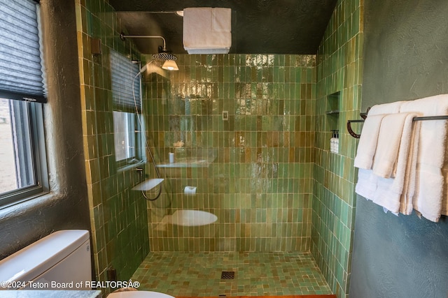 bathroom with toilet and tiled shower