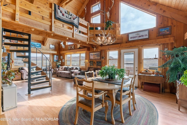 581 E Fork Rd, Dubois, WY 82513 - dining space with wood walls, high vaulted ceiling, wood finished floors, stairway, and a chandelier